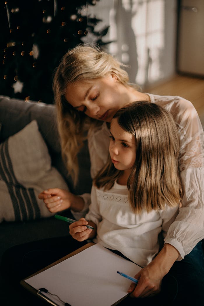 Services-02 Heartwarming moment of a mother and daughter drawing together in cozy indoor setting.